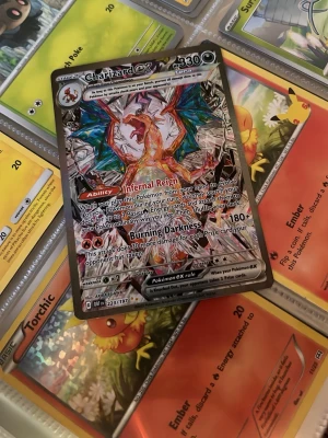 Charizard EX Pokémonkort - Säljer ett Charizard EX Pokémonkort med holografisk yta.