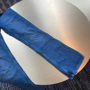  bootcut jeans från Gina Tricot  - Säljer ett par blå jeans med rak passform och klassisk femficksdesign. Jeansen har normal midja och är tillverkade i ett mjukt denimtyg som känns skönt att bära hela dagen. Perfekta för dig som gillar en tidlös och enkel stil.