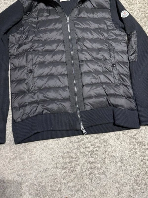 Svart Monclear cardigan - Snygg svart jacka från Moncler med quiltat mönster och dragkedja framtill.