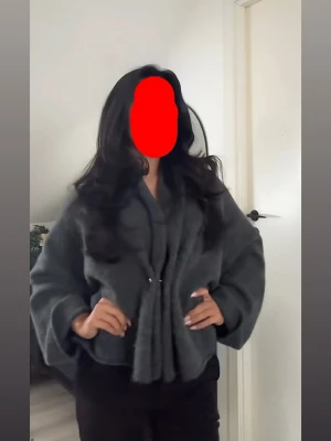 Mörkgrå oversized cardiganjacka - Säljer en mörkgrå, oversized cardiganjacka med breda ärmar och avslappnad passform. Jackan har en mjuk, fluffig struktur och stängs framtill med en knapp. Perfekt för lager-på-lager och ger en trendig, chill vibe till din outfit.