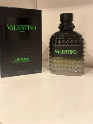 Valentino Uomo Born In Roma parfym - Valentino Uomo Born In Roma Green Stravaganza är en parfym i en lyxig glasflaska med nitar och svart kork. Flaskan har en gradient från svart till transparent och rymmer 100 ml. Förpackningen är svart med grön text och ger en modern, edgy känsla.