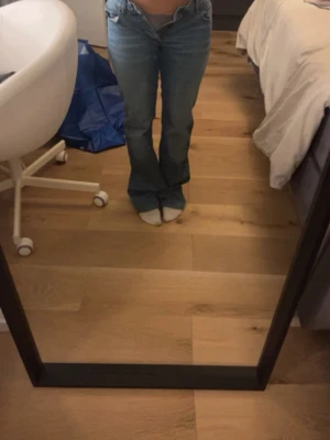 Blå bootcut jeans med låg midja - Säljer ett par klassiska blå bootcut jeans med låg midja. Jeansen har en snygg passform som sitter tajt över låren och släpper ut vid vaden. Perfekta för dig som gillar en retro vibe och vill ha ett par jeans som sticker ut lite extra.