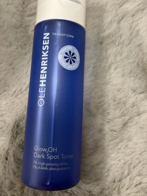 OLEHENRIKSEN Glow2OH Dark Spot Toner - Glow2OH Dark Spot Toner från OLEHENRIKSEN i en blå plastflaska med vitt lock. Tonern innehåller 7% AHA-syror och är framtagen för att reducera mörka fläckar och ge huden lyster. Perfekt för dig som vill ha en effektiv och fräsch ansiktsrutin.