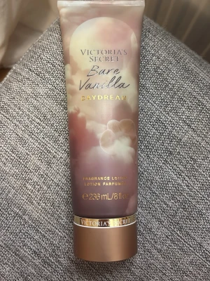 Limited Victoria's Secret Bare Vanilla Daydream - Fragrance lotion från Victoria's Secret i doften Bare Vanilla Daydream. Tuben är i mjuka beige och guldiga toner med drömlikt molnmotiv. Innehåller 236 ml och har en lyxig känsla med guldiga detaljer. Perfekt för dig som älskar vaniljdoft.