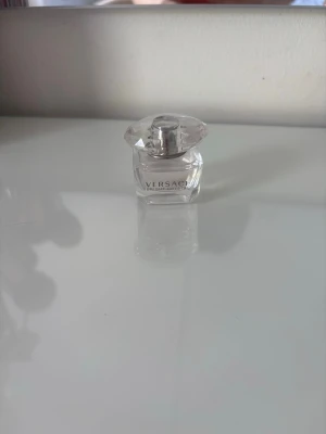 Versace Bright Crystal parfym - Versace Bright Crystal parfym i en elegant, genomskinlig glasflaska med silverfärgad kork och kristalliknande lock. Doften är fräsch och feminin, perfekt för dig som gillar lyxiga och stilrena parfymer.