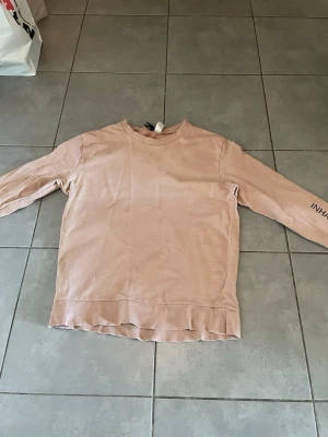 Brun-Beige Träninigströja -  Detta är en brun beige träningssttoja från H&M Divided den har väldigt bra skick har inte varit använd ofta. Jag kan inte gå lägre än 70 kr.