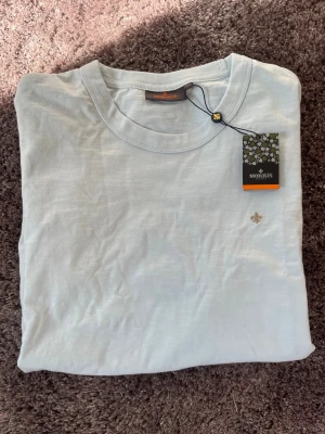 Ljusblå Morris T-shirt  - Säljer nu denna helt oanvända Morris T-shirten. Storlek L, och en väldigt somrig färg. Bara att höra av sig med funderingar! 