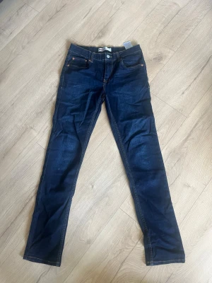 Mörkblå skinny jeans från Levi's - Snygga mörkblå skinny jeans från Levi's 512 slim taper. Jeansen har en smal passform och är tillverkade i stretchigt denim för extra komfort. Storlek:xs/s, endast använda 1 gång, skick 9/10