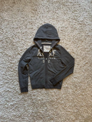 Abercrombie & Fitch zip hoodie grå - Snygg grå hoodie i mycket bra skick. Står storlek L men sitter mycket mindre mer som en S, tror det är dam storlek. 