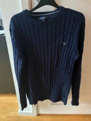 Mörkblå kabelstickad tröja Gant - Kabelstickad mörkblå tröja från Gant! Bra skick! Sparsamt använd! Herrstorlek S! Nypris 1500 kr. Mitt pris 349 kr! Kan gå ner lite i pris vid snabb o enkel affär! Kan köpas tillsammans med mina andra plagg för billigare pris! Tveka inte på att höra av om ni har funderingar!