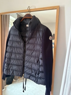 Svart pufferjacka från Moncler - Snygg svart pufferjacka från Moncler med quiltad front och hög krage. Jackan har dragkedja, skönt lent matrika vid ärmarna, verkligen rätt årstid att ha jackan! Knappt använd inga defekter eller liknade! Har inge kvitto men den är äkta, scanningen kommer direkt till Moncler sidan❤️