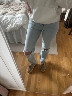 Ljusblå Jeans  - Säljer ett par ljusblå jeans med slitningar och hål vid knäna. Jeansen har en rak passform och är högmidjade. Ca 82cm i innerbenslängd🤍