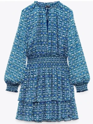 Blå mönstrad kortklänning från Zara - Blå klänning från Zara som går att ha öppen/v ringad men även knuten i ringningen🩵 Jättefint mönster!