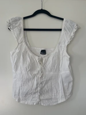 Somrig topp - Superfin topp från gina tricot Axelband med spetsdetaljer och knappar + knytning fram Figurnära passform Använd fåtal gånger  Inga anmärkningar
