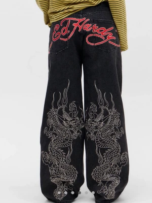Svarta Ed Hardy jeans med drakbrodyr - Unika svarta jeans från Ed Hardy med bred passform och stora vita drakbroderier på bakbenen. Bakfickorna har en stor röd Ed Hardy-logga broderad. Jeansen är tillverkade i denim och har en riktigt streetig vibe. OBS dom är slitna vid fötterna, kan skicka bild om man vill! 