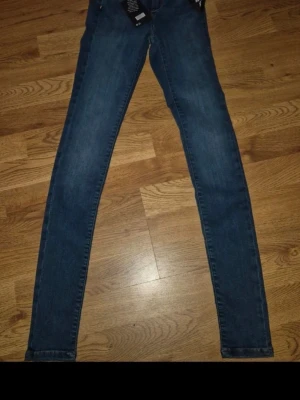Gina Tricot Molly mörkblå NYA jeans stretch, high waist, stuprör storlek XS - Säljer ett par blå skinny jeans Never Denim med superflex-material från Gina Tricot i Molly modellen. Så Snygga jeans i en mörkblå färg med hög midja och tighta ben.   Superstretchiga skinny jeans med hög midja. Jeansen är mörkblå och har figurnära, bekväm passform med smala ben. De har dragkedjegylf, och knapp fram.   Storlek XS. Längd 31 Självklart toppskick, då dom är helt nya med taggen kvar! Måste ses! Djur och rökfritt hem
