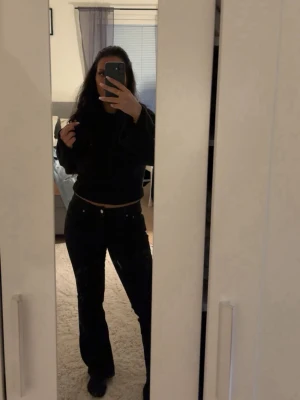 Svarta bootcut jeans från gina - Säljer ett par svarta bootcut jeans med hög midja och klassisk femficksdesign. Jeansen har en snygg passform som framhäver benen och är perfekta till en avslappnad eller trendig look. Materialet är stretchigt för extra komfort.