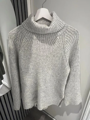 Ljusgrå stickad tröja från Ginatricot, XS - Mysig ljusgrå stickad polotröja från Ginatricot. Tröjan har bred ribbstickning, hög polokrage och långa ärmar. Storlek XS💖