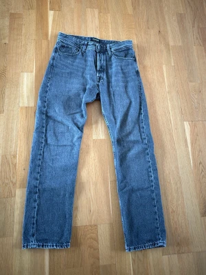 Blå raka jeans från Jack & Jones - Säljer ett par klassiska mörkgrå jeans från Jack & Jones med rak passform. storlek W29 L30, inte använda alls mycket max 5 gånger, reaktivt nyköpta. ser inte jätte använda ut, väldigt sköna.