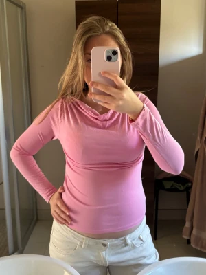 Rosa långärmad topp från Monki XS - Säljer en rosa långärmad topp från Monki i storlek XS. Toppen har en snygg draperad halsringning och är figurnära i modellen. Perfekt att styla med jeans eller kjol för en trendig look.