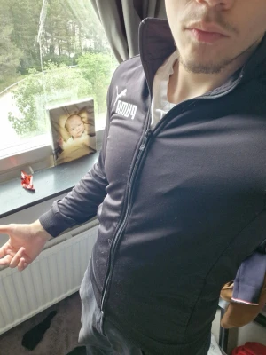 Svart ziptröja från Puma - Säljer en svart ziptröja från Puma med vit logga på bröstet. Tröjan har hög krage, hel dragkedja och ribbade muddar vid ärmsluten. Perfekt för träning eller chill. Materialet är mjukt och stretchigt, troligen polyesterblandning.