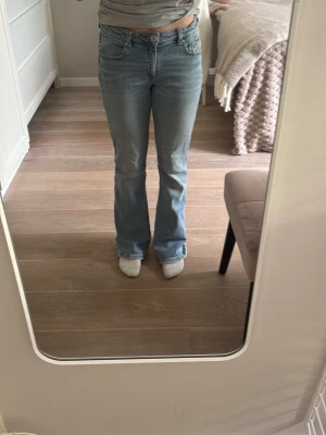 Ljusblå bootcut jeans - Säljer ett par ljusblå bootcut jeans med klassisk, normal midja. Jeansen har en lätt utsvängd passform nedtill och är i den perfekta ljusblå nyansen. Jeansen är från Gina Tricot och de är storlek 152
