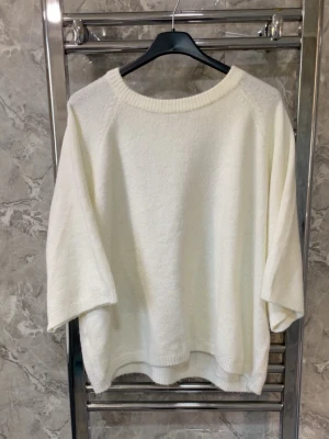 Vit oversized stickad tröja - Säljer en vit oversized stickad tröja med rund halsringning och trekvartsärmar. Tröjan har en avslappnad passform och ribbade kanter vid hals och nederkant. Perfekt för lager på lager och enkel att styla till olika outfits.