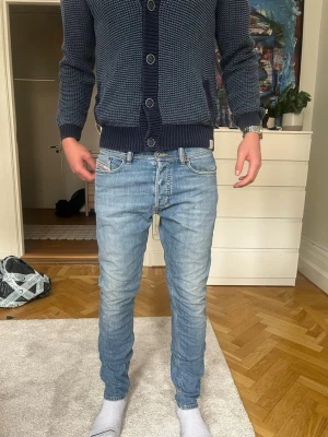 Ljusblå slim fit jeans from Diesel  - Säljer ett par ljusblå slim fit jeans med klassisk femficksdesign och normal midja. Jeansen har en snygg tvättad look och smal passform hela vägen ner. Perfekta till en avslappnad stil och passar till det mesta i garderoben.