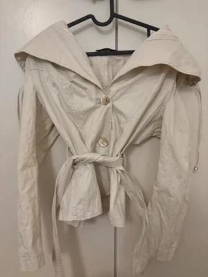 Trenchcoat  - Stilren beige trenchkappa med krage, knäppning framtill och midjebälte. Kappan har långa ärmar och en avslappnad passform. Perfekt för dig som gillar klassisk men trendig stil. Har inga bilder på tyvärr men skickar samma dag vid snabba köp!! 💗