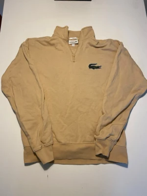 Beige Lacoste Quarter zip - Beige Lacoste, quarter-zip. Size S och loose fit. Använd, bra skick.
