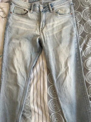 Ljusblå regular tapered jeans H&M - Säljer ett par ljusblå jeans från H&M i modellen regular tapered. Jeansen har klassisk femficksdesign, knappgylf och är tillverkade i denim. Perfekta för dig som gillar en avslappnad men ändå snygg passform.