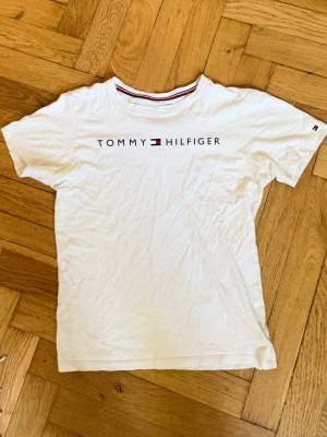Vit Tommy Hilfiger t-shirt - Rikigt fräsch t shirt till sommaren! Bara att höra av sig vid funderingar!!