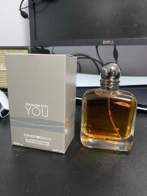 Emporio Armani Stronger With You 100ml - Emporio Armani Stronger With You är en herrparfym i en stilren, fyrkantig glasflaska med silverfärgad rund kork. Doften är varm och modern, perfekt för dig som gillar eleganta och maskulina parfymer. Flaskan rymmer 100 ml och har en lyxig känsla.