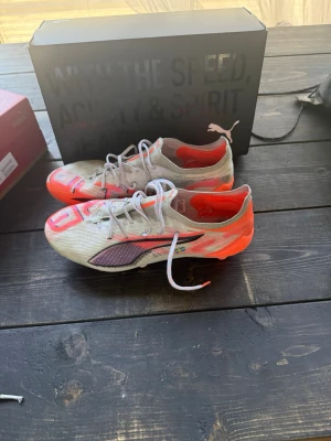 Puma Ultra fotbollsskor vit/orange - Säljer ett par Puma Ultra fotbollsskor i vitt med orange och svarta detaljer. Bra skick!
