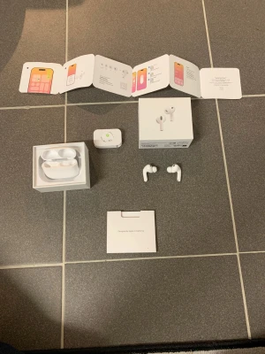 Apple AirPods Pro med laddningsetui - Säljer ett par vita Apple AirPods Pro med tillhörande laddningsetui och originalförpackning. Hörlurarna är in-ear och har en stilren, kompakt design i plast. Allt som behövs för att komma igång ingår, inklusive manual och tillbehör.