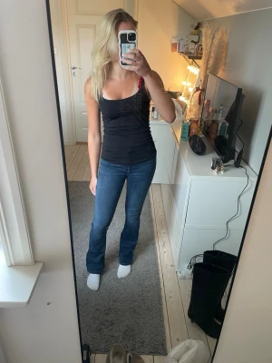 Mörkblå bootcut jeans - Säljer ett par mörkblå bootcut jeans med normalhög midja. Jeansen har en snygg tvätt och är tillverkade i ett stretchigt denimtyg som sitter bekvämt. 