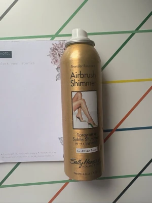 Sally Hansen Airbrush Shimmer spray, leg/body make up  - Airbrush Shimmer från Sally Hansen är en sprayfoundation i guldigt skimmer som ger huden en jämn och glansig finish. Kommer i en metallisk sprayburk med vit kork och passar alla hudtoner. Perfekt för att snabbt få en subtil glow på kroppen.  Tried on a couple of times only 