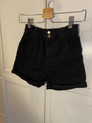 svarta jeans-shorts  - Ett par svarta jeans-shorts från h&m. är i barnstorlek 140.