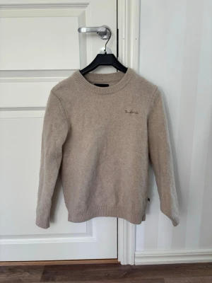 Beige stickad tröja från Bondelid - Säljer en snygg beige stickad tröja med en skön design. Perfekt för dig som vill ha en stilren look som passar både till vardags och mer uppklädda tillfällen. Den mjuka färgen gör den enkel att matcha med jeans, chinos eller lager-på-lager över en skjorta. Perfekt för en liten kallare sommarkväll! 😁 Passar dig som är runt 160 cm lång, har använt några fåtal gånger då det är ett fint skick. Slänger med en överraskning i paketet 😋