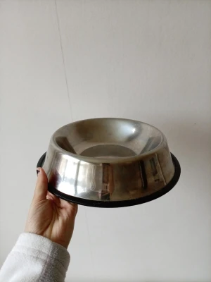 Rund matskål i rostfritt stål - En rund matskål i blankt rostfritt stål med svart gummikant undertill som gör att den står stadigt. Perfekt för mat eller vatten till husdjur. Enkel att rengöra och tålig mot slitage. Passar både till hund och katt.