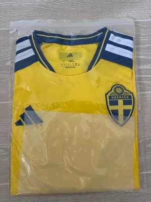 Sverige matchtröja vm gul  - Gul matchtröja från Adidas. Helt oanvänd och oöppnad. Perfekt för fotboll eller att heja på Sverige i.