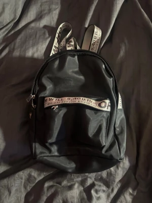 Svart ryggsäck från Off-White - Snygg svart ryggsäck från Off-White med vita axelband. Sönder vid en dragkedja därför pris 
