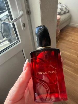 Giorgio Armani Si Passione Intense 50 ml - Snygg parfym från Giorgio Armani i en elegant röd glasflaska med svarta och guldiga detaljer. Flaskan har en modern, fyrkantig form och är dekorerad med subtila mönster i glaset. Perfekt för dig som gillar exklusiva dofter och stilren design. Testad fåtal gånger