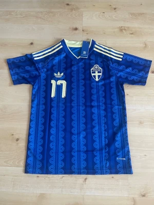 Gyökeres #17 Sverige bortatröja (Storlek S)   -  Sveriges bortamatchtröja 2026 med GYÖKERES 17 på ryggen i storlek small (S) men passar även exakt bra för storlek medium (M)