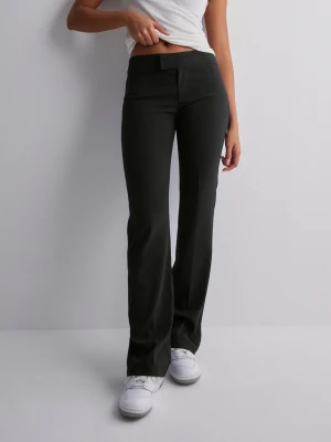 Svarta bootcut kostymbyxor - Säljer ett par svarta kostymbyxor med bootcut passform och hög midja. Byxorna har en enkel design utan synliga fickor och stängs med hake och dragkedja. Perfekta för en clean och stilren look.