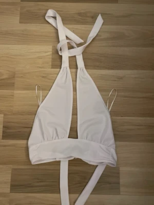Vit halterneck topp - säljer en vit halterneck topp i storlek Xss från hm helt ny.