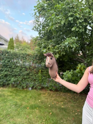 Brun käpphäst med garnman - Säljer en handgjord käpphäst i brunt tyg med mörkbrun garnman och vita detaljer vid ögon och mule. Hästen har en gul grimma som går att ta av. Perfekt för dig som gillar att leka eller samla på käpphästar. Säljs med ett par gula tyglar, och både handgjord grimma och träns. Hos mig har han hetat Scooby doo/Scooby men du bestämmer självklart helt själv!🥰