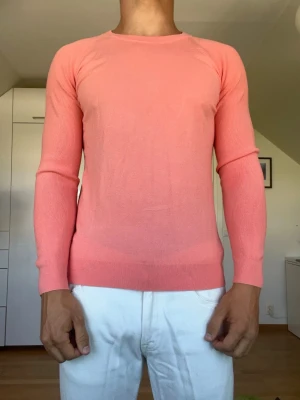 Korallfärgad/ rosa stickad tröja - Rosa/ korallfärgad tröja från Peter Millar tillverkad i 72% viskos och 28% polyester. Strl M. Inga defekter. Modellen är 178 cm och väger 77kg. Hör gärna av dig vid frågor!
