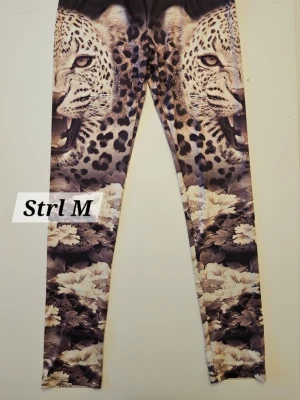 Leggings med leopardtryck och strass - Unika leggings med stort leopardtryck och coola strassdetaljer. Stretchigt material som sitter snyggt och bekvämt. Väldigt fint skick!