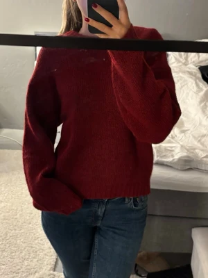 Vinröd stickad tröja - En enkel och snygg vinröd stickad tröja med rund hals och långa ärmar. Tröjan har en rak passform och ribbstickade muddar vid ärmslut och nederkant. Perfekt att matcha med jeans för en avslappnad look🥰